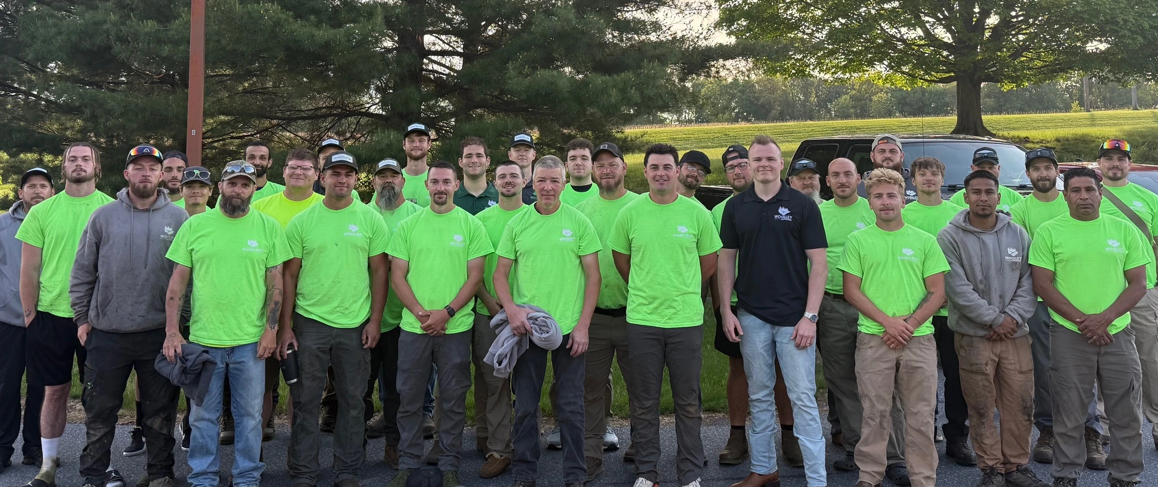 Team Photo With Green Woolley Bros Lawn Care Uniform