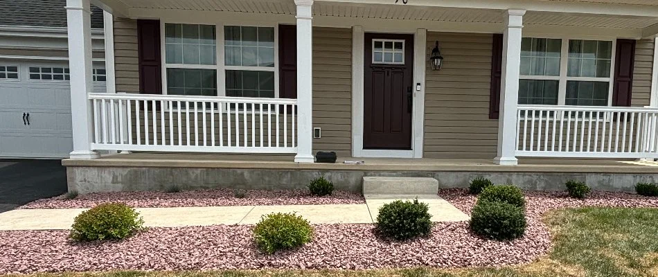 Residential, rock landscape bed in Lititz, PA, with shrubs.